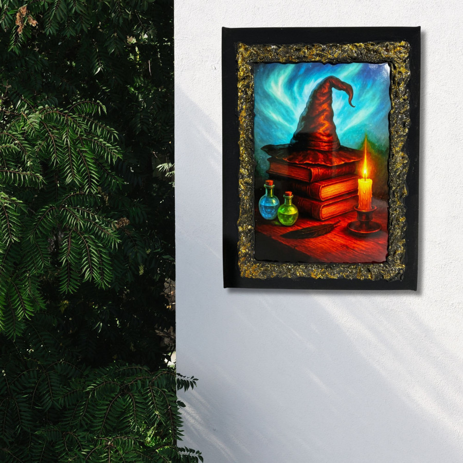 Cuadro sombrero de bruja y grimorios decorado a mano colgado en pared